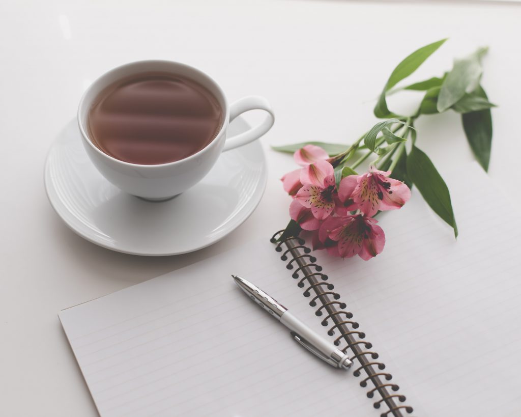 coffee and flower with a note and a pen